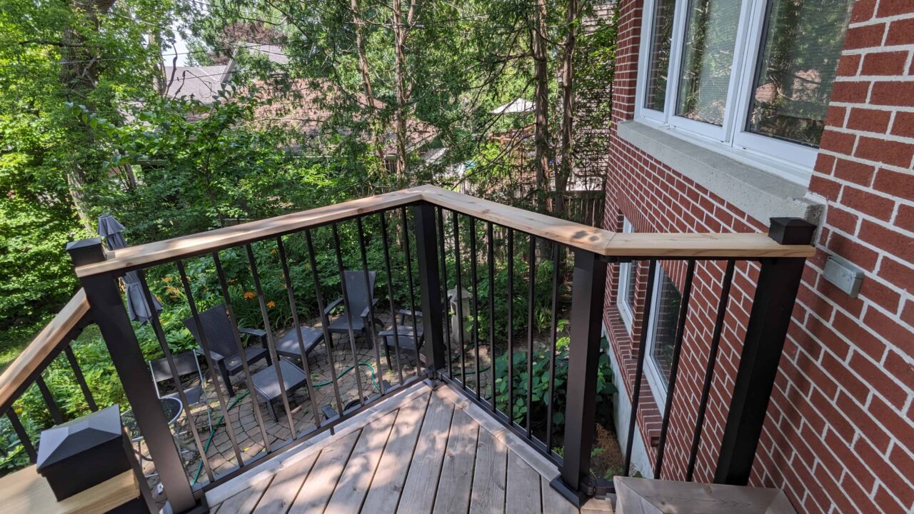 Deck detail with Fortress black rail and cedar drink rail right side