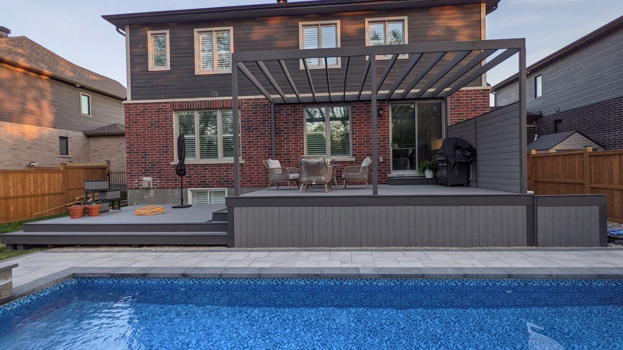 Finished Fiberon Cottage deck with Earl Grey trim, glass railing, pergola, and pool patio in Manotick