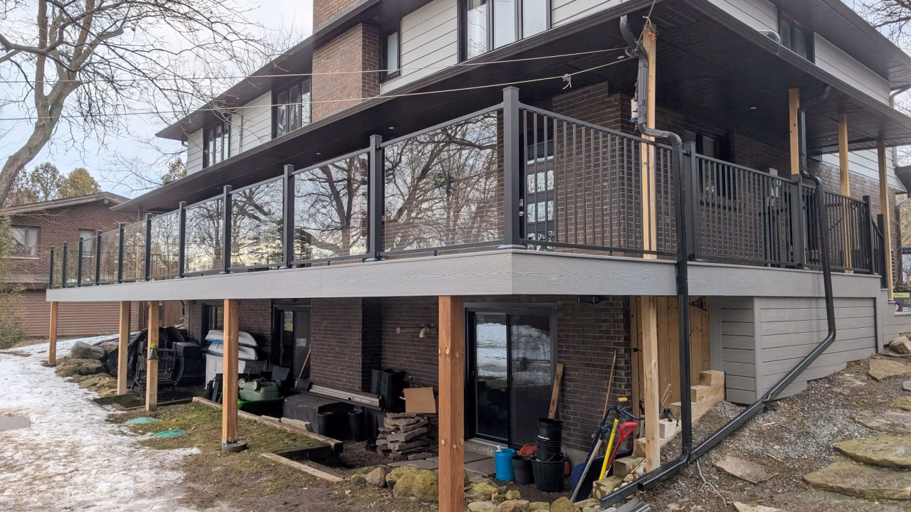 Raised Fiberon Cottage deck with Earl Grey trim and glass railing in Manotick